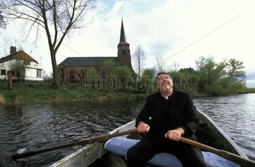 Millingerwaard the vicar of the church of Kekerdom the only church in Europa situated inside the dikes in a rowing boat on his way to the church