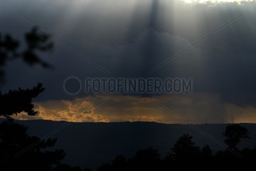 Twilight rays and sky of storm on a wind mill farm France