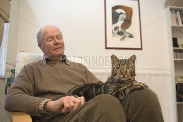Homme retraité caressant un chat sur ses genoux