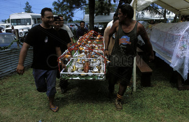 Tonga  roasted pig and other food stuff is brought in for a party attended by members of the royal family