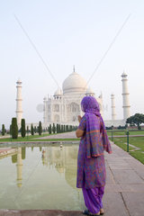 Hindu woman with colorful sari veil in the quiet peaceful Taj Mahal one of the wonders of the world in Agra India