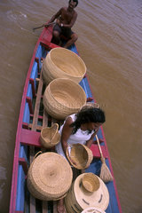 Craftsmanship. Artisans transport straw baskets in a boat by the rivers of Amazon rain forest. State: Rondonia  Brazil.