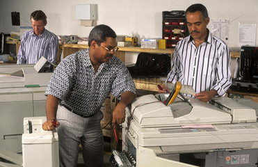 Black african american men in black owned minority business situation repairing a copier in office