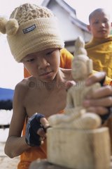 Young novice sculpting a statue Luang Prabang Laos