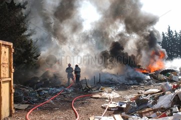 Pompiers intervenant sur un feu dans une décharge sauvage