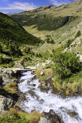 Hiker and Juclar waterfall in Incles valley Pyrenees Andorra