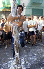 The Tomatina in Bunol  man climbing pole rubbed with soap