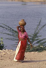 Woman carries on head a water earthenware jar the Rajasthan India