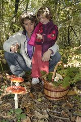 Young girl with her mom in front of a Fly agaric