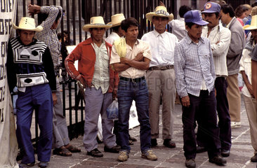 Mexico  Mexico City; a group of unemployed men waiting at a barred fence