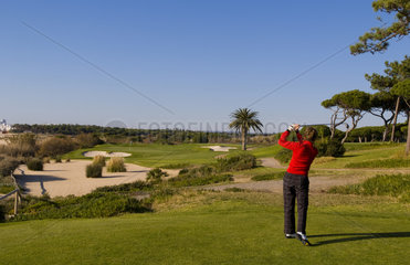 Woman golfing on the expensive Ocean Club in the exclusive Quinta do Lago vacation resort area of the Southern Algarve in Portugal