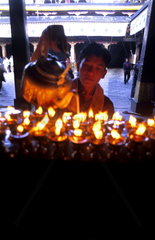 Monk pouring Yak wax into candles at the Jokhang temple in capital city of Lhasa Tibet China