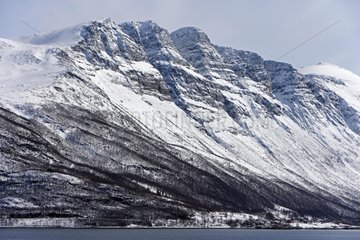 Snow-covered mountain on the coast of North Sea Norway