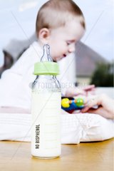 Baby old of 8 months near a nursing bottle without Bisphenol