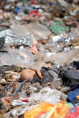 Doll through garbage in a dump