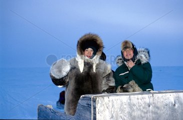 Kinder von Taloyoaq auf einem Konvoi von Schneeschottern