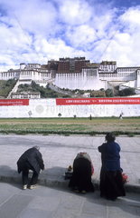Locals praying in front of the wonderful Potala Palace the home of the Dalai Lama in capital city of Lhasa Tibet China
