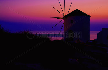 Oia Santorini Greece and an old famous windmill at sunset