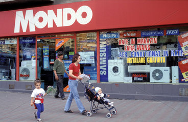 10043531 Roemenie Boekarest familie loopt voor een winkel met witgoed. foto:Ron Giling/Lineair www.lineairfoto.nl