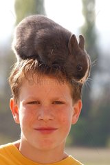 Enfant portant un lapin sur sa tête