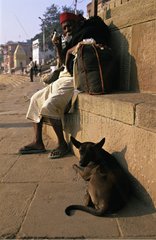 Mann und Hund sitzen auf Ghats Indien