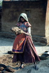 INDIA : Gujarat. The Kutch. Tribal woman making mudbricks. In the village of Bhirandiara.