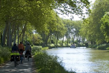 Cyclists on the banks of the Canal du Midi Castelnaudary France