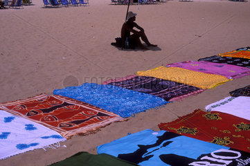 Street vendor at Copacabana beach  Rio de Janeiro  Brazil. Towels for sale  street-seller  informal economy  open-air market.