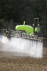 Spraying tractor in a field on bare ground