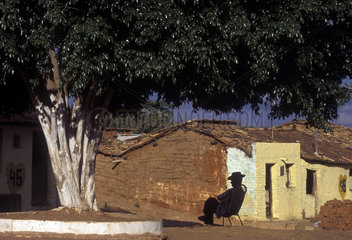Elderly man rests under a tree shadow in Northeastern Brazil. Rural life. State: Ceará. Daily lify in Sertão  back country. Region affected by drought. Poor houses.