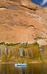 Tourists riding water on raft in the Coilorado River near Glen Canyon Dam in Page Arizona in West USA