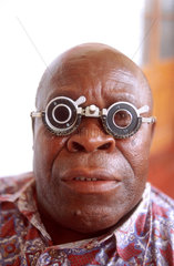 Man wearing spectacles for eye sight tests. Chimoio provincial Hospital. Manica. Mozambique