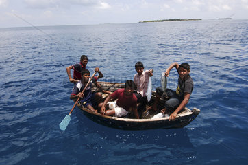 Maldives  boys catching fish in the Indian Ocean
