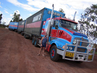 Australia  West coast  Broom. Typical Ozi trucker proudly stands next to his road train.