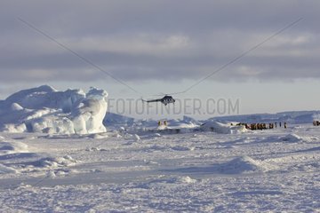 Helicopter landing tourists on ice Antarctic Peninsula