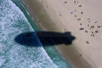 Dirigible flies over Copacabana beach  Rio de Janeiro  Brazil. shadow  bathers  aerial view of tropical beach.