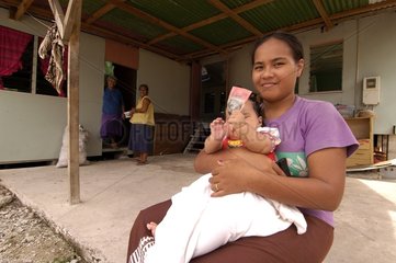 Polynesischer und ihr Kind vor dem Haus Funufuti Tuvalu