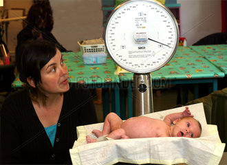 10052094 Baby op weegschaal tijdens controle bij consultatieburo