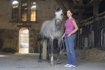 Young woman and her horse in an equestrian center France