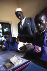 Counting money at a biological coffee cooperative in Kagera