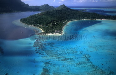 Aerial of the green water and clear blue colors of the islands of Bora Bora in Tahiti in French Polynesia