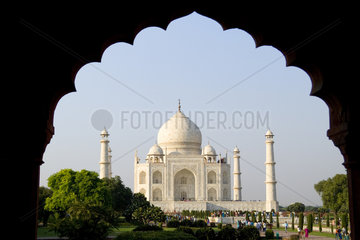 Photograph through a doorway showing sunrise at the famous Taj Mahal one of the wonders of the world in Agra India