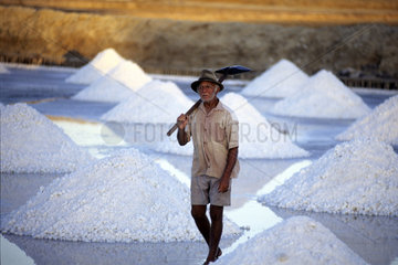 Aged man at hard work. Latin America  Northeastern Brazil. Salt manual production.toughness  hardness shovel