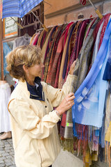 Middle age woman shopping for fabric clothes in Cesky Krumlov in Czech Republic