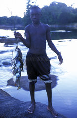 Saramaccan boy fishing in the Pikin Rio river