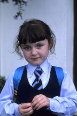 Life in Ireland school girl age 6 in traditional uniform in Adare Ireland