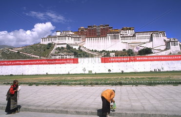 Locals praying in front of the wonderful Potala Palace the home of the Dalai Lama in capital city of Lhasa Tibet China