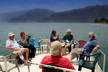 Tourists on boat relaxing near Panajachel on remote Lake Atitlan in Guatemala
