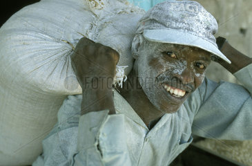 A worker carrying a sack of flour