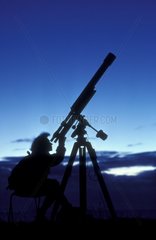 Astronome observant le ciel à l'aide d'une lunette astro